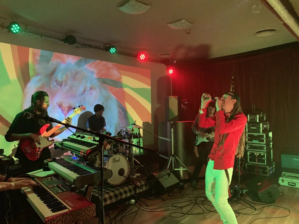 A band in front of a colourful projection