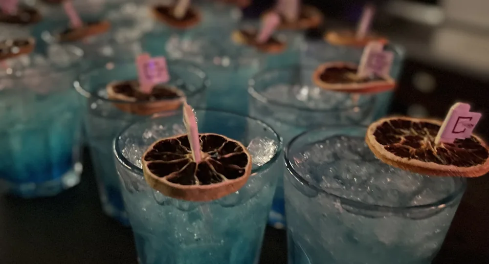 Blue cocktails with dried orange and a club-logo pick