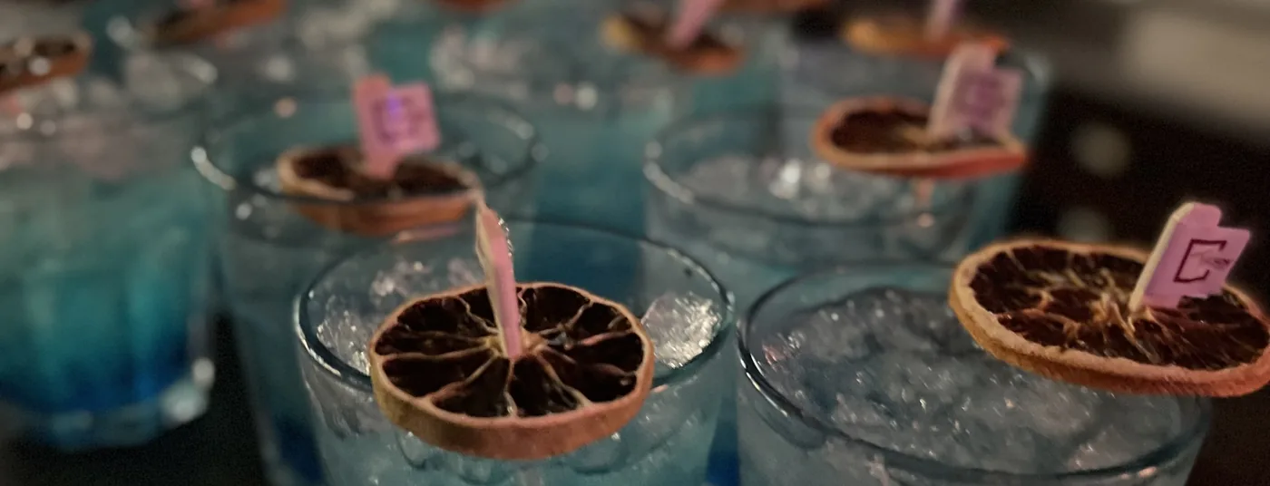 Blue cocktails garnished with dried citrus on the bar