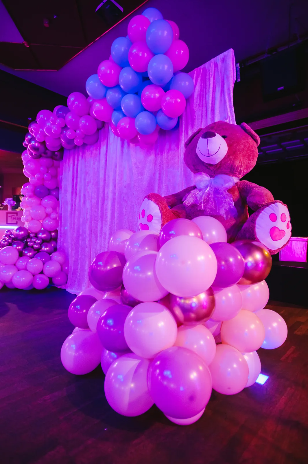 Pink and blue balloon decoration in detail, with a giant teddy bear