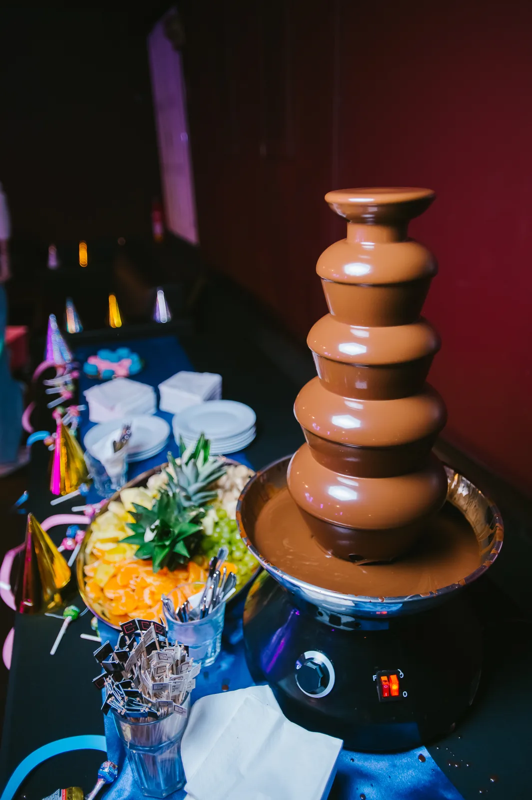 A chocolate fountain and a fruit platter on the buffet table