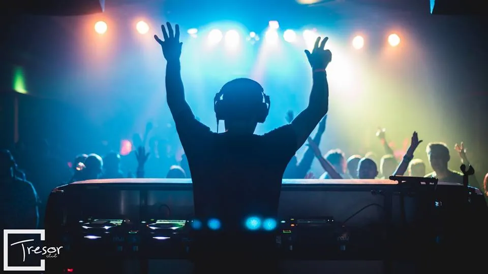 A guest with arms raised in front of the stage
